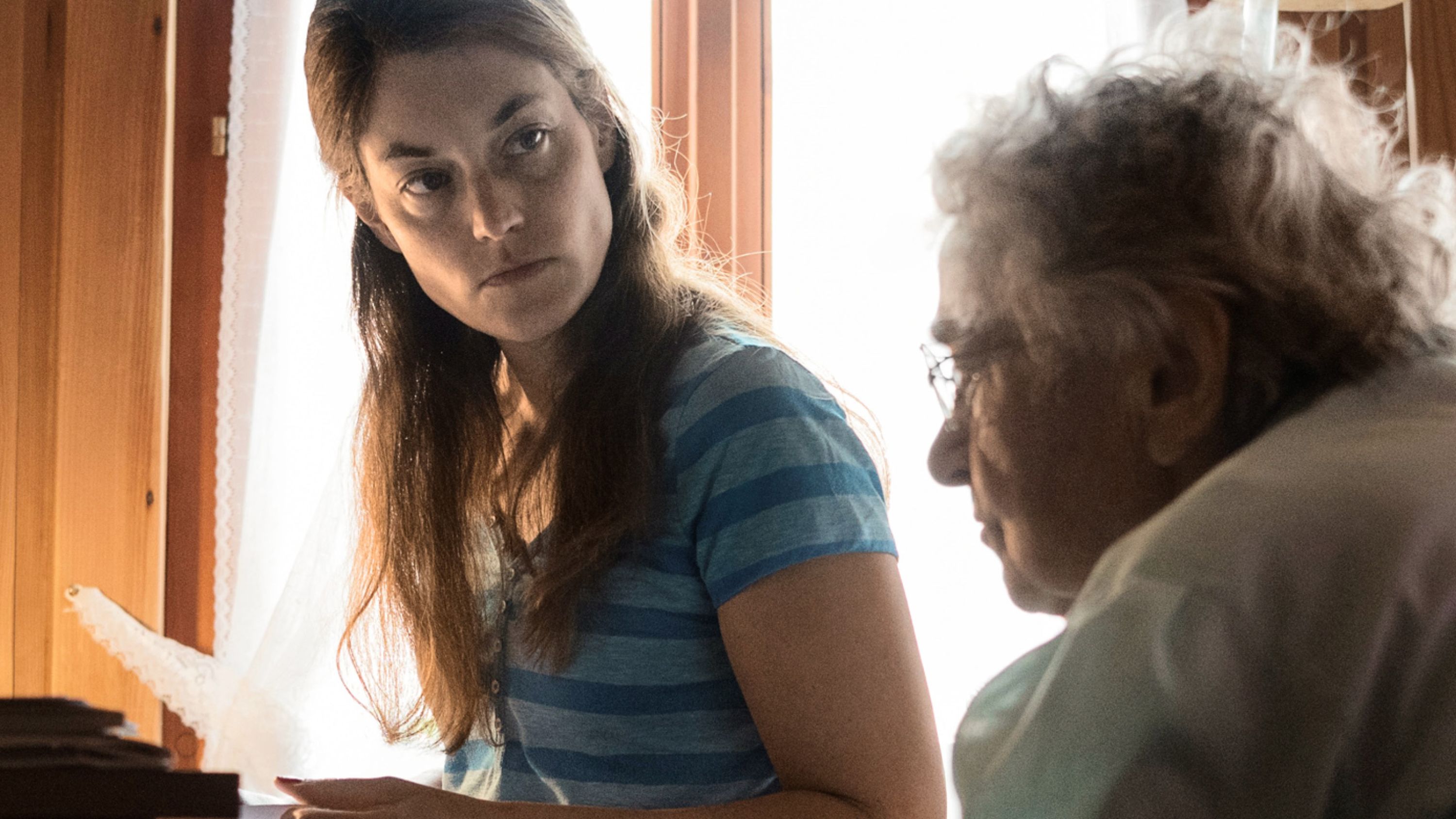 Une femme regarde une dame âgée d'un air sérieux.